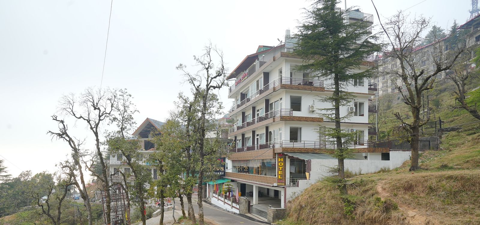 Image of the hotel from a side angle with trees in the background | DLS Hotel Shiva Sanctuary and Spa